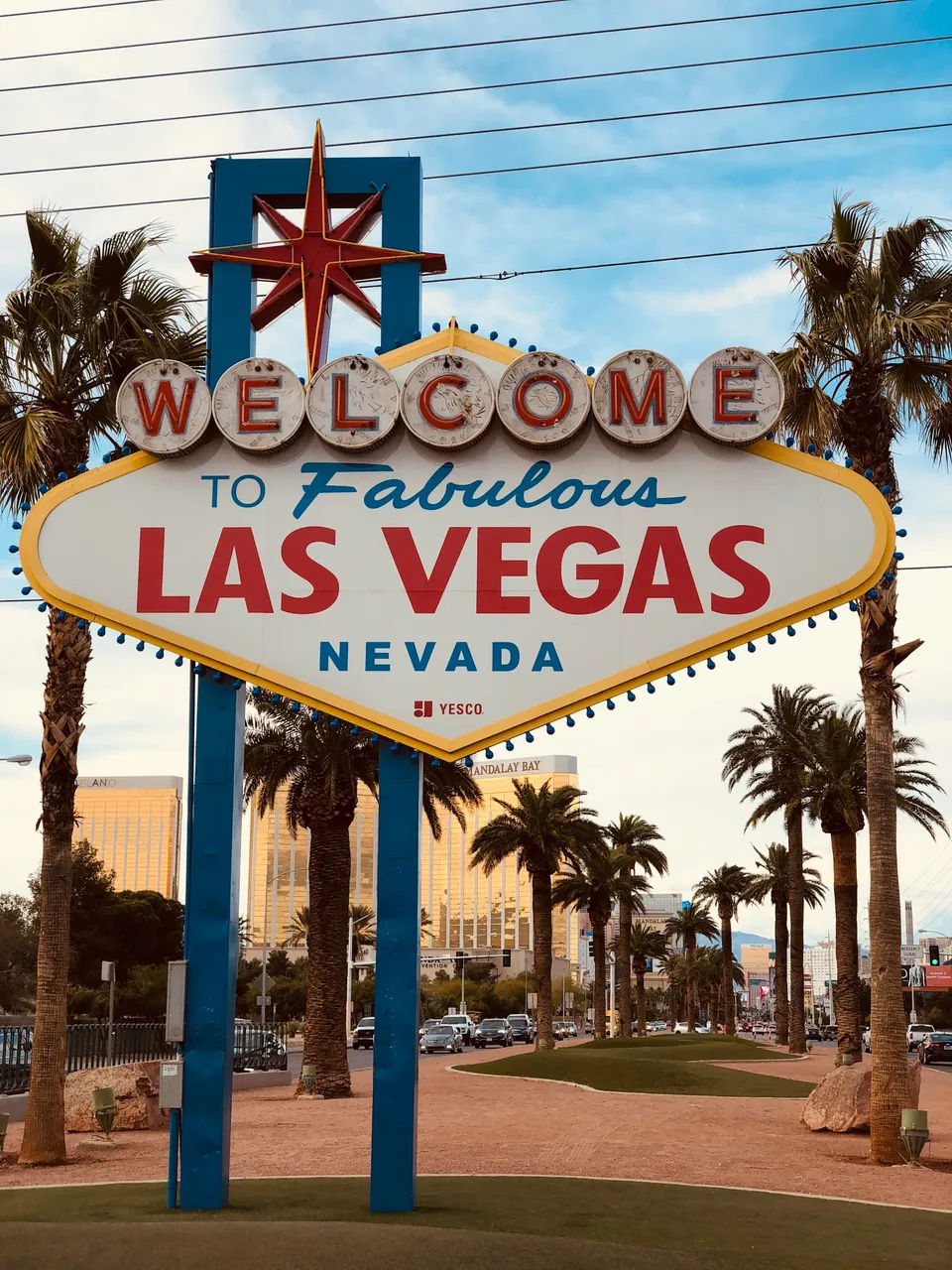 Welcome to Fabulous Las Vegas sign among palm trees under a blue sky in Las Vegas, Nevada
