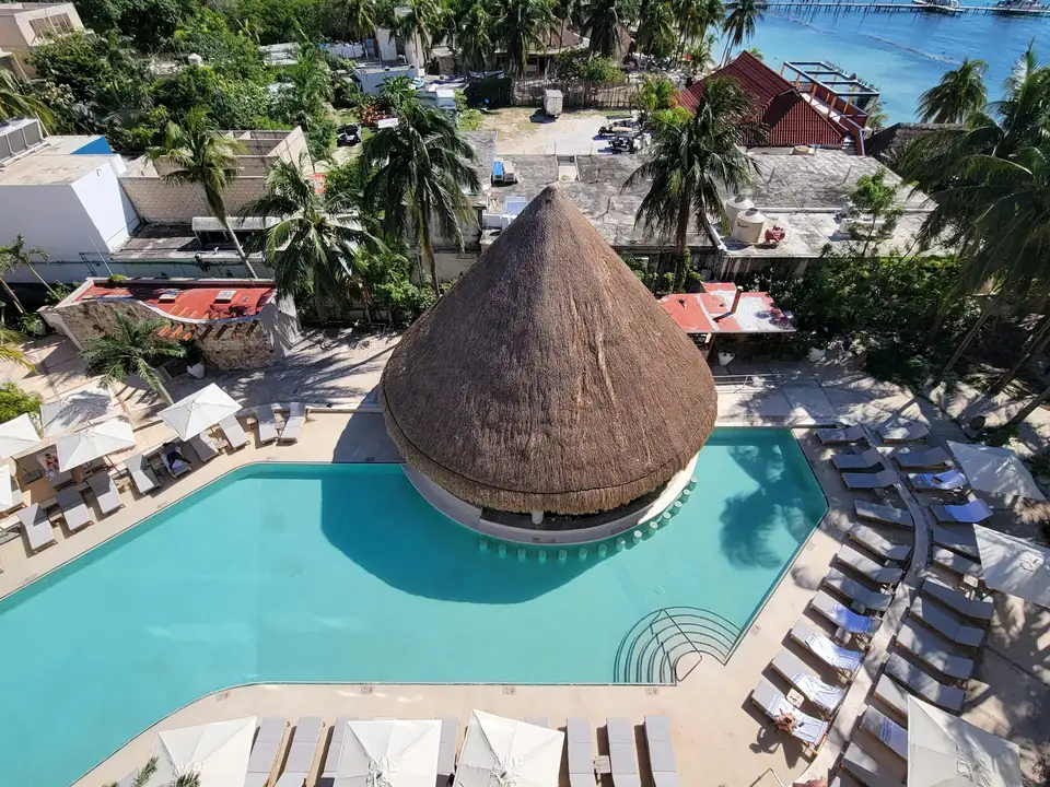 Vista aérea de la alberca con palapa de un resort todo incluido en el Caribe mexicano